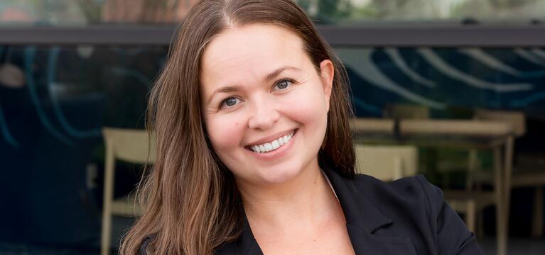 Photo of a woman with brown shoulder length hair and a black jacket