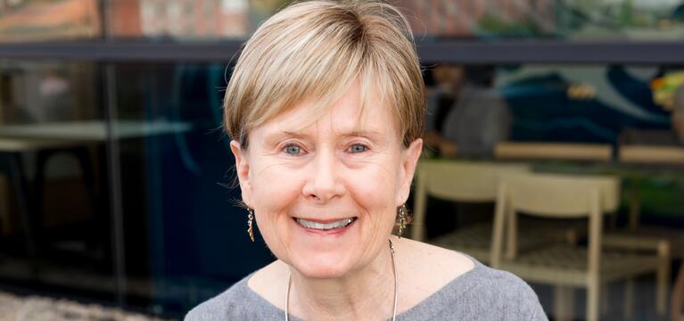 Photo of a woman with short hair wearing a gray sweater