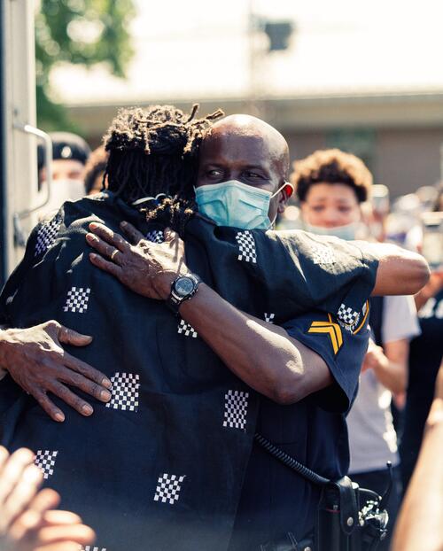 Police officer embracing community member