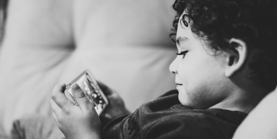 Photo of a child holding a smartphone by Diego Passadori