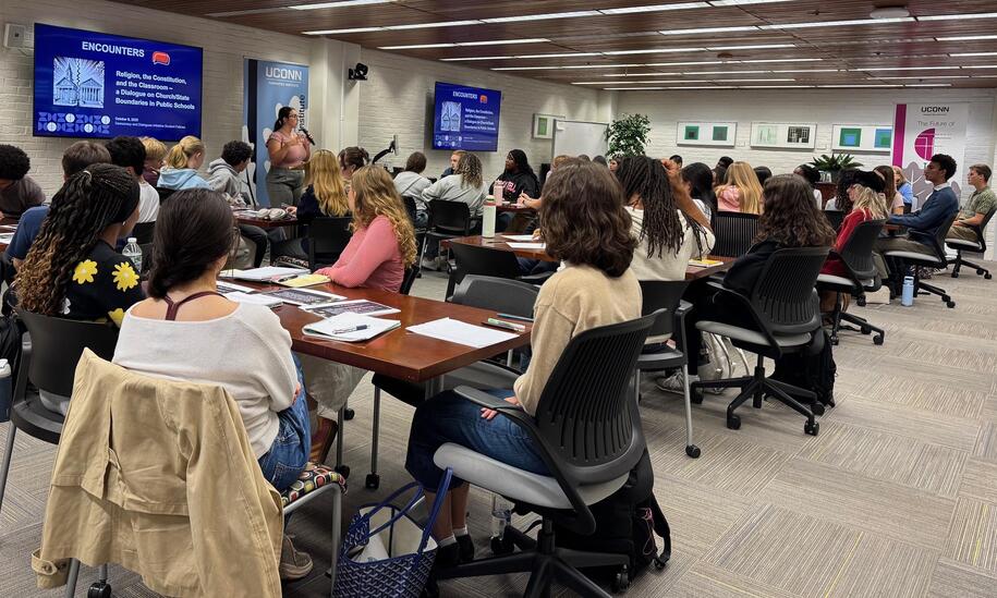 Photo of person speaking in front of a group of students