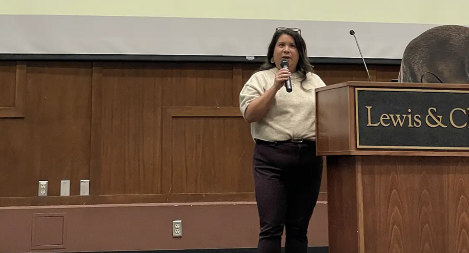Photo of Danielle Torres speaking to a crowd using a microphone
