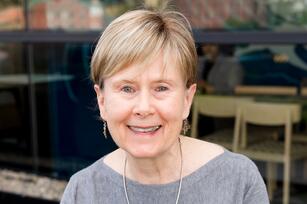 Photo of a woman with short hair wearing a gray sweater