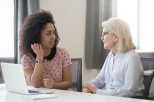 Photo, woman of color talking with older white woman