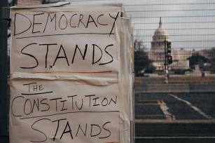 Photo: US Capitol Building with sign reading "Democracy Stands, the Constitution Stands" by Brendan Beale on Unsplash