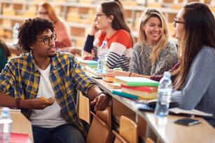 Photo of college students in a large lecture hall talking